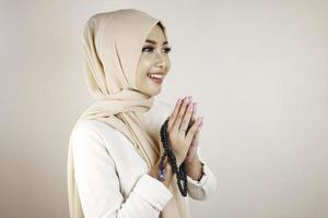 retrato de alegre jovem muçulmana asiática bonita sorrindo e segurando contas de oração. conceito de eid mubarak foto