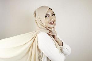 mulher muçulmana vestindo roupas tradicionais e hijab isolado no fundo branco. hijab é feito de forma criativa voando. idul fitri e conceito de moda hijab. foto