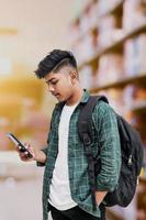 estudante universitário indiano usando smartphone em fundo branco. foto