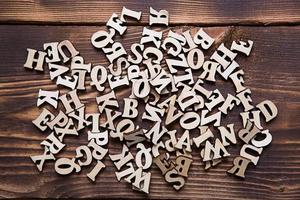 letras do alfabeto inglês em um fundo escuro de madeira. o conceito de educação, jogos de palavras, bordado. espaço para texto foto