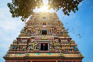 templo hindu tradicional kidangamparambu sree bhuvaneswari na índia em allapuzha allepi kerala. edifício alto com figuras coloridas da mitologia indiana e deuses, bando de pássaros vivos. turismo, viagens foto