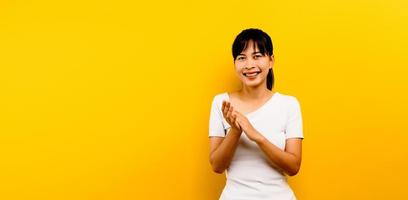 mulher aplaudindo mulher asiática batendo palmas após uma apresentação de conferência sobre fundo amarelo isolado. com espaço de cópia foto