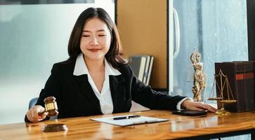 jovem mulher asiática séria advogada empresária sentada na mesa trabalhando digitando no computador portátil no escritório da corporação contemporânea. conceito de tecnologias de negócios. foto