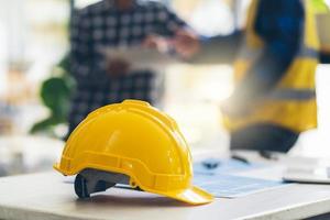 arquitetos conceituais, engenheiro segurando caneta apontando arquitetos de equipamentos na mesa com uma planta no escritório, engenheiros e arquitetos trabalham em projetos de brainstorming. foto