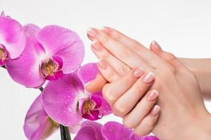 manicure francesa e flor de orquídea foto