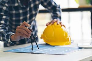 arquiteto e engenheiro reunião planejamento para um novo projeto com equipamentos de construção na mesa, arquiteto e engenheiro trabalhando com planta. foto