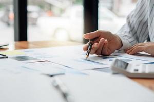 close-up de contador ou banqueiro verificando resultados de investimento, calcula economias financeiras, calcula impostos anuais e conceitos econômicos. conceito de cálculo financeiro. foto