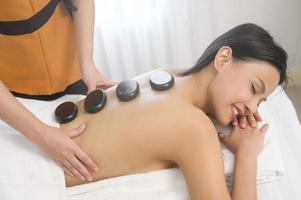 jovem mulher bonita asiática relaxando e desfrutando do conceito de massagem, spa e tratamento de beleza