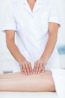 fisioterapeuta fazendo massagem nas pernas foto