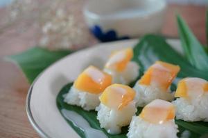 Arroz pegajoso de manga madura com leite de coco autênticas sobremesas tailandesas foto