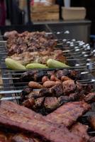 espetos de carne grelhados na brasa, com fumaça. comida de rua. foto