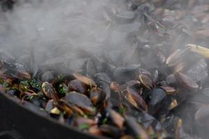 close-up de mexilhões cozidos em um festival de comida de rua, pronto para comer frutos do mar fotografados com foco suave foto