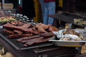 espetos de carne grelhados na brasa, com fumaça. comida de rua. foto