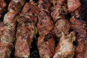 espetos de carne grelhados na brasa, com fumaça. comida de rua. foto