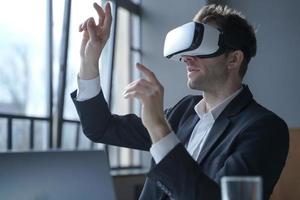 trabalhador de escritório animado homem usando óculos vr tocando objetos com as mãos no mundo digital foto