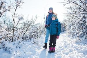 mulher com uma criança em uma caminhada de inverno nas montanhas. foto