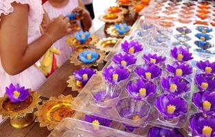 as velas de flores violetas estão na mesa para os budistas, peguem e respeitem a estátua de buda no templo, na tailândia. foto