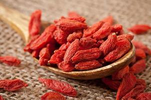 bagas vermelhas secas de goji em colher de pau foto