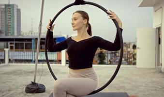 mulher em roupas esportivas fazendo ioga do céu no telhado à noite, quando o sol se põe. autocuidado e conceitos de saúde. foto