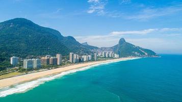 vista aérea da favela da rocinha, maior favela do brasil na serra do rio de janeiro e skyline da cidade atrás foto