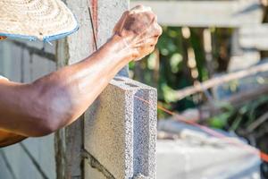 alvenaria de trabalhadores estão construindo paredes com blocos de cimento e argamassa. foto