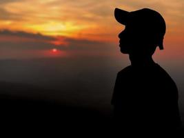 silhueta de um homem de chapéu ao pôr do sol foto