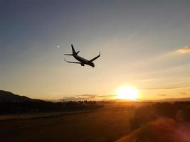 avião se aproximando de pouso em um pôr do sol foto