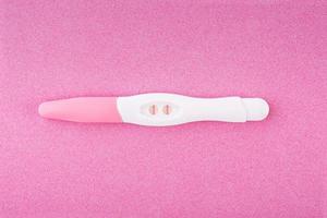 teste de gravidez positivo isolado no fundo rosa