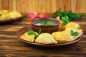 deliciosas empanadas assadas em fundo de madeira foto