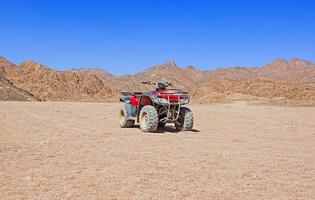 quadriciclo vermelho no deserto foto