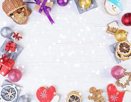 fundo de natal. presente de natal, brinquedos, biscoitos de gengibre, especiarias e decorações em fundo de madeira. vista do topo foto
