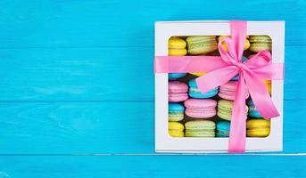 deliciosos bolos de macaron coloridos em fundo de madeira foto