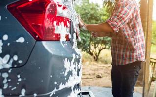 lavagem de carro com solução de espuma na estação de atendimento ao carro foto