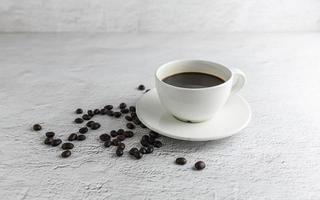 xícara de café com grãos de café no fundo branco foto