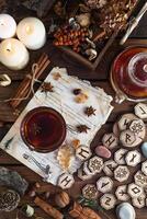 runas de madeira estão sobre a mesa entre os papéis com notas. há uma caneca de chá ao lado. astrologia e esoterismo. foto