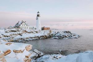 paisagem costeira de neve com farol foto