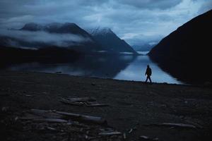 pessoa perto de um lago à noite foto