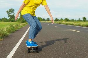 mulher no skate de surf com estrada na zona rural. foto