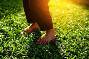 parte do pé de uma menina no parque no sol quente da tarde foto