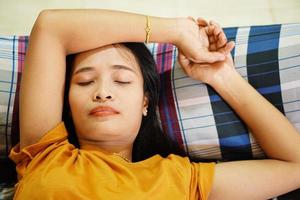 mulher asiática na camisa laranja dormindo cansado depois do trabalho