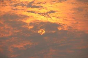 luz laranja e pôr do sol à noite. nuvem fofa cinza coberta de sol. foto