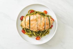 macarrão fettuccine espaguete ao molho pesto com frango grelhado foto