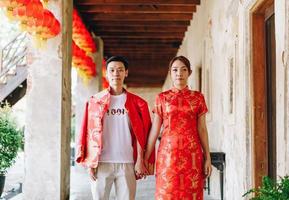 feliz jovem casal asiático em vestidos tradicionais chineses foto