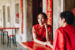 feliz jovem casal asiático em vestidos tradicionais chineses foto