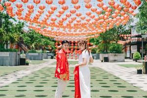 feliz jovem casal asiático em vestidos tradicionais chineses foto