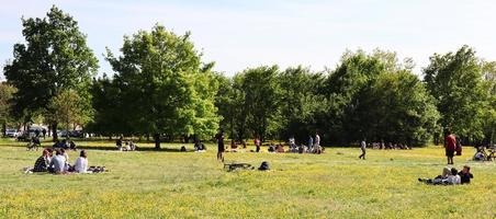 bolonha, itália, 18 de abril de 2022, pessoas relaxando no gramado do parque. descansando no parque juntos após a pandemia. Bolonha, Itália.