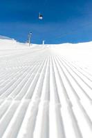 pista de esqui recém-preparado em um dia ensolarado