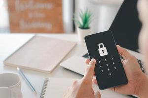 hackear um celular de phishing com uma senha para acessar um smartphone, ameaças de segurança online e fraudes. um jovem com um telefone celular e laptop está seguro em sua conta bancária. foto