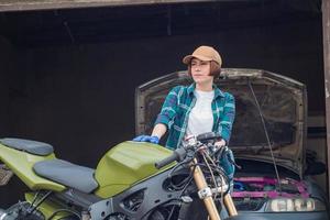 mecânico feminino consertando carro em uma garagem foto