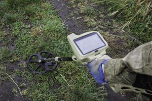 soldado usando um detector de metais em campos foto